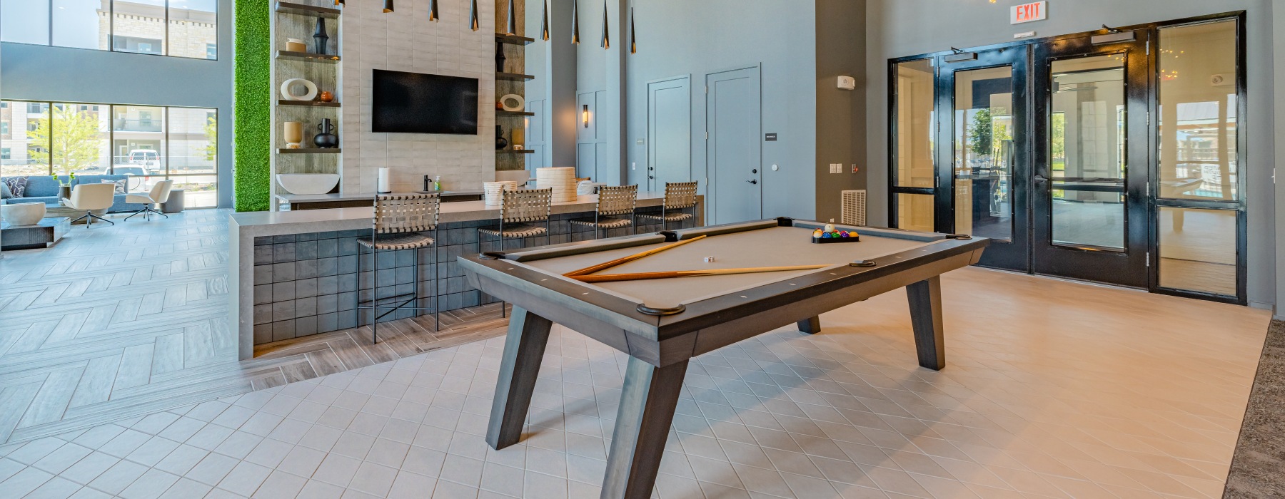 Modern resident clubhouse at Brea Frisco featuring game lounge, seating areas, and contemporary finishes