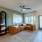 Spacious and well lit living room with wood flooring, large windows and open access to the kitchen