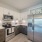 Spacious and well lit kitchen with wood flooring and stainless steel appliances