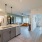 Spacious and well lit kitchen with wood flooring and stainless steel appliances