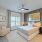 Large well lit bedroom with plush carpets and large windows 