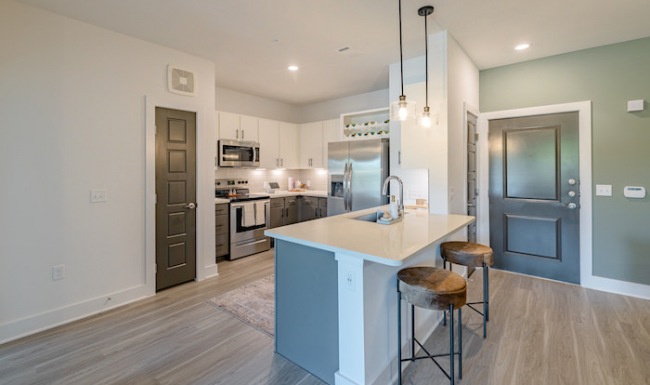 Kitchen Spacious and well lit kitchen with wood floors and stainless steel appliances